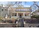 Charming two-story home featuring a porch with columns, a stone retaining wall, and a wrought-iron gate at 728 N Ogden St, Denver, CO 80218