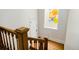 Bright staircase featuring hardwood floors, wooden railings and a window with colorful art adding a unique touch at 728 N Ogden St, Denver, CO 80218