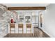 Beautiful kitchen with white cabinetry, an island with bar seating, stone accent wall, and stainless steel appliances at 3437 N Jackson St, Denver, CO 80205