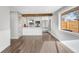 Open-concept living area with luxury vinyl plank floors, a view into the kitchen, and large windows at 3437 N Jackson St, Denver, CO 80205