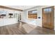 Open-concept living area featuring luxury vinyl plank floors, large windows, and a view into the modern kitchen at 3437 N Jackson St, Denver, CO 80205