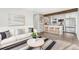 Stylish living room with a white sofa, modern decor, and a view into the kitchen with bar seating at 3437 N Jackson St, Denver, CO 80205