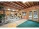 Spacious basement gym features exposed beams and ductwork, various exercise machines, and a gray rubber floor mat at 1220 Scarsbrook Ct, Monument, CO 80132