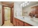 Well-lit bathroom features a long vanity, neutral tile flooring, and a shower-tub combo with a white shower curtain at 1220 Scarsbrook Ct, Monument, CO 80132