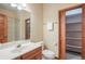 A modern bathroom that provides a walk-in shower, storage shelving, and a spacious vanity with wood cabinets at 1220 Scarsbrook Ct, Monument, CO 80132