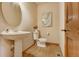 Neutral powder room featuring pedestal sink, toilet, decor, mirror and light-colored walls at 1220 Scarsbrook Ct, Monument, CO 80132