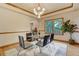 Bright dining room with modern table, chairs, chandelier, and large window overlooking greenery at 1220 Scarsbrook Ct, Monument, CO 80132