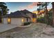 Charming home with a large garage, well-lit exterior, and colorful landscaping at 1220 Scarsbrook Ct, Monument, CO 80132