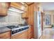 A close-up of kitchen features, including the cooktop, stainless fridge, and wood cabinets at 1220 Scarsbrook Ct, Monument, CO 80132