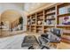 Cozy seating by a built-in bookshelf with a view to the staircase and dining room at 1220 Scarsbrook Ct, Monument, CO 80132