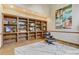 Relaxing seating area with a custom wood bookcase, contemporary artwork, and light area rug at 1220 Scarsbrook Ct, Monument, CO 80132