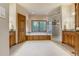 Bright, spacious primary bathroom featuring a standalone tub, walk-in shower, and wood cabinets at 1220 Scarsbrook Ct, Monument, CO 80132