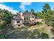 Rear exterior view showcasing a multi-story home with a large deck, stone accents, and mature trees at 1220 Scarsbrook Ct, Monument, CO 80132