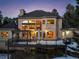 Expansive rear view of the home with multi-level deck and patio, large windows, and snow-covered ground at 1220 Scarsbrook Ct, Monument, CO 80132