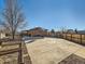 Wide backyard with a large concrete patio, deck, brick home, and wooden privacy fence at 438 N 11Th Ave, Brighton, CO 80601