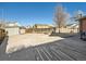 Large concrete backyard patio with a sandbox, basketball hoop, storage shed, and wooden fence at 438 N 11Th Ave, Brighton, CO 80601