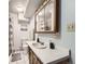 Well-lit bathroom with wooden vanity, mirrored cabinet, toilet, and shower with curtain at 438 N 11Th Ave, Brighton, CO 80601