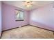 A simple bedroom with lilac walls, a window with blinds, carpeted floors, and a ceiling fan at 438 N 11Th Ave, Brighton, CO 80601