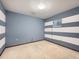 Spacious bedroom featuring blue and white striped walls, carpeted floors, and a window at 438 N 11Th Ave, Brighton, CO 80601