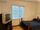 Bedroom with a bed, side table, TV, wooden floors, and natural light from the window at 438 N 11Th Ave, Brighton, CO 80601