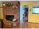 Inviting living room featuring a brick fireplace and wood laminate flooring at 438 N 11Th Ave, Brighton, CO 80601