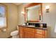 Bathroom featuring a granite vanity, framed mirror, modern lighting, and tile flooring at 31299 Manitoba Dr, Evergreen, CO 80439