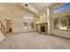 Inviting living room featuring a stone fireplace, high ceilings, large windows, and neutral carpet at 31299 Manitoba Dr, Evergreen, CO 80439