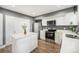 Kitchen featuring stainless appliances, white cabinets, an island, and durable laminate floors at 8624 Mariposa St, Thornton, CO 80260