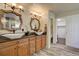 Elegant bathroom features double sinks, granite countertop, rustic mirrors, and a separate toilet room at 15960 E Aberdeen Ave, Centennial, CO 80016