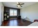 Bright bedroom with hardwood floors, ceiling fan, dark accent wall, and ample natural light at 15960 E Aberdeen Ave, Centennial, CO 80016