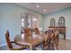 Elegant dining room with a wooden table, six chairs, hardwood floors, and an open view to the living area at 15960 E Aberdeen Ave, Centennial, CO 80016