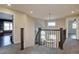 Elegant hallway showcasing a staircase with a chandelier, hardwood floors, and multiple doorways at 15960 E Aberdeen Ave, Centennial, CO 80016