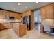 Spacious kitchen featuring stainless steel appliances, custom cabinets, a center island, and tile flooring at 15960 E Aberdeen Ave, Centennial, CO 80016