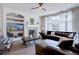 Bright living room featuring a fireplace, built-in shelving, a ceiling fan, and a large window with natural light at 15960 E Aberdeen Ave, Centennial, CO 80016
