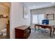 Functional home office with a large desk, dresser, and half bathroom featuring neutral walls and a window at 15960 E Aberdeen Ave, Centennial, CO 80016