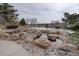 Community pond with rock features and surrounding natural landscape for all residents to enjoy at 15960 E Aberdeen Ave, Centennial, CO 80016
