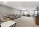 Spacious finished basement featuring plush carpeting, a large sectional sofa, and a built-in desk area at 17233 W 93Rd Pl, Arvada, CO 80007