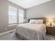 A bright bedroom features a queen bed, light gray walls, and ample natural light at 17233 W 93Rd Pl, Arvada, CO 80007