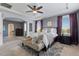 A well-lit bedroom with gray walls, tray ceiling, and carpet; bedroom flows into the bathroom at 20293 E Shady Ridge Rd, Parker, CO 80134