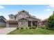 Beautiful two-story home showcasing stone accents, a well-manicured lawn, and a charming front porch with seating at 20293 E Shady Ridge Rd, Parker, CO 80134