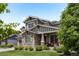 Charming home with a stone facade, covered porch, and lush landscaping, creating an inviting curb appeal at 20293 E Shady Ridge Rd, Parker, CO 80134