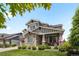 Attractive gray home with stone accents, a covered porch, and a neatly landscaped front yard at 20293 E Shady Ridge Rd, Parker, CO 80134