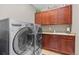 A laundry room has a front-loading washer and dryer, cabinets, a sink, and countertop at 20293 E Shady Ridge Rd, Parker, CO 80134