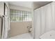 Neutral bathroom with a shower/tub combination, window, and white towels at 6235 E 6Th Avenue Pkwy, Denver, CO 80220
