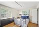 Bedroom with hardwood floors, a black metal bed frame, and shuttered windows at 6235 E 6Th Avenue Pkwy, Denver, CO 80220