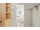 Walk-in closet leading to a bathroom, with built-in shelving and neutral colors at 6235 E 6Th Avenue Pkwy, Denver, CO 80220