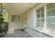 Inviting front porch with stone floor, textured brick walls, windows with shutters, and modern glass block accent at 6235 E 6Th Avenue Pkwy, Denver, CO 80220