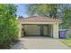 Spacious garage with tile roof, concrete floor, brick walls, storage space, and ample parking, partially shaded by trees at 6235 E 6Th Avenue Pkwy, Denver, CO 80220