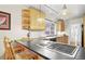 Bright kitchen featuring wood cabinets, a cooktop island, and a breakfast bar area at 6235 E 6Th Avenue Pkwy, Denver, CO 80220