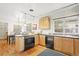 Bright kitchen with black appliances, wood cabinetry and a dining area with chandelier at 6235 E 6Th Avenue Pkwy, Denver, CO 80220